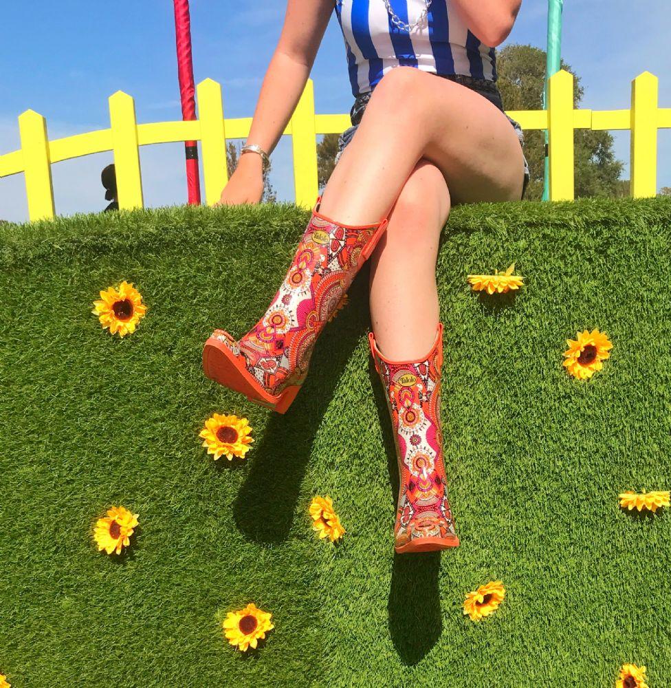 Zesty and full of life, these Talolo Women's orange aztec patterned, funky cowboy welly boots are heeled to give you sophistication and will reach the middle of the calf. Lined for comfort.