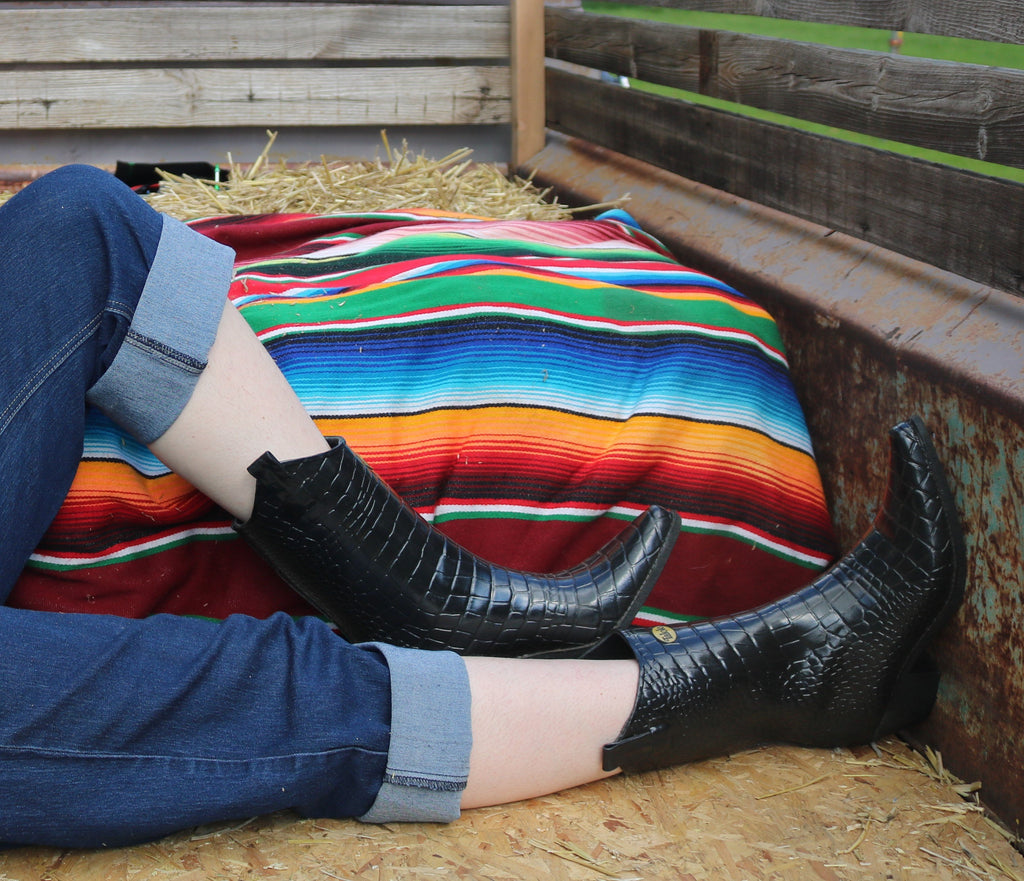 Girl sitting in the back of a truck wearing jeans and Talolo Boots - black mock croc cowboy style wellies